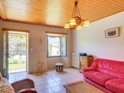 ein Wohnzimmer mit einem roten Sofa und einem Tisch in der Unterkunft Beautiful villa 150 m from the beach in Vic-sur-Cère