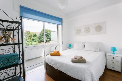 a bedroom with a bed and a large window at PortoVivo Quental Apartamento in Porto