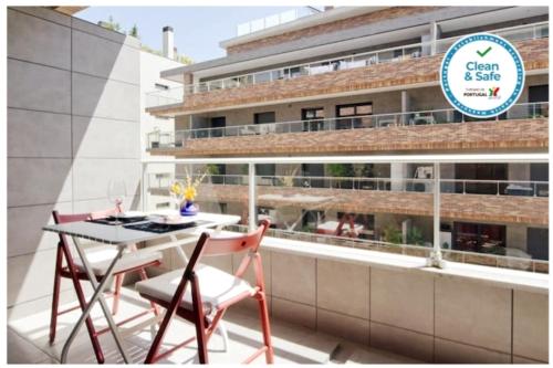 a balcony with a table and chairs and a building at Parque Nações / Jardins Cristo Rei in Lisbon