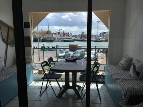 einen Tisch und Stühle auf einem Balkon mit Hafenblick in der Unterkunft Le Studio Goëland in Trouville-sur-Mer