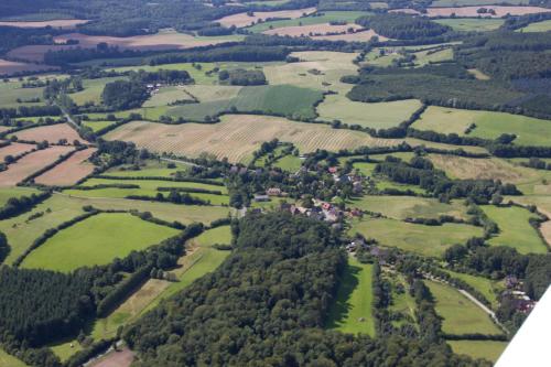 an aerial view of a village in a field at "Haus auf dem Berg" in Westensee