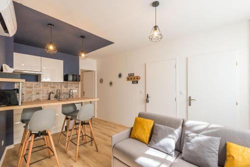 un salon avec un canapé et une cuisine dans l'établissement Le Cosy Narbonnais, à Narbonne