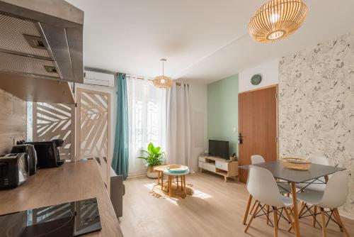 a kitchen and living room with a table and chairs at L'Exotique Narbonnais in Narbonne