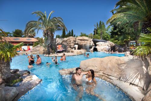 un groupe de personnes dans une piscine d'un complexe hôtelier dans l'établissement TopSun Argelès Camping La Sirène 2 bedroom 25m2 max 4 personnes Inc bebe pas d'enfants sans parents, à Argelès-sur-Mer