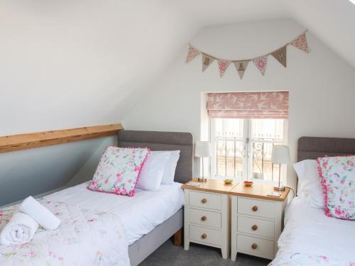 two twin beds in a room with a window at Swanage Driftwood in Swanage