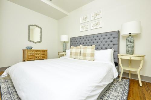 a white bedroom with a large bed and a table at Sonder Telfair Square in Savannah