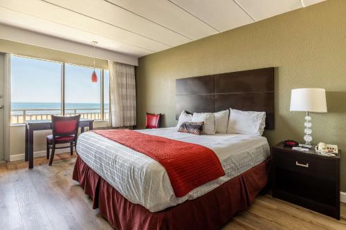 a bedroom with a bed with a view of the ocean at Sandcastle Resort in Virginia Beach