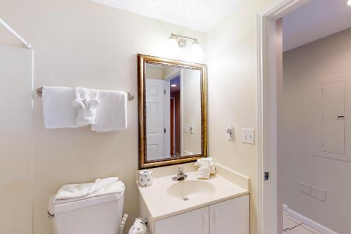 a bathroom with a toilet and a sink and a mirror at Sterling Sands 803 Destin (Condo) in Destin