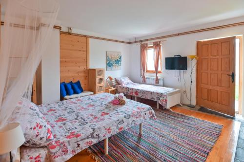 un soggiorno con due letti e una TV di Neva Apartments a Mokra Gora
