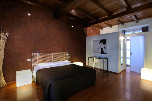 a bedroom with a bed and a table with a laptop at B&B Terres D'Aventure Suites in Turin