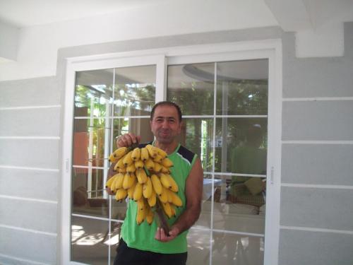 a man is holding a bunch of bananas at Hotel Vanilla in Fethiye
