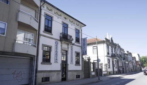 a row of white buildings on a city street at Hotel Portucalense in Porto
