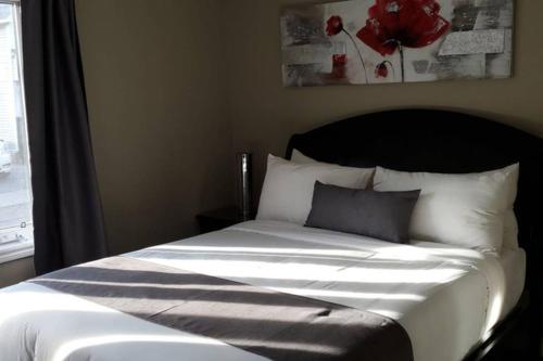 a bed in a bedroom next to a window at 2-Bedroom Apartment Sweet #2 by Amazing Property Rentals in Gatineau