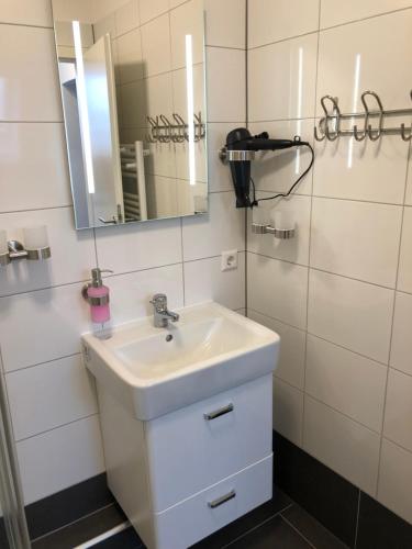 a bathroom with a white sink and a mirror at Schiller Pension in Bielefeld