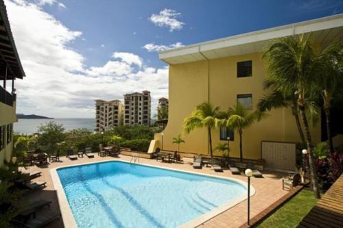 einem Pool vor einem Gebäude in der Unterkunft Nice 2 level condo with ocean view - ideal for families in Playa Flamingo