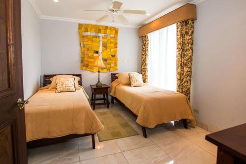 1 dormitorio con 2 camas y ventana en Exclusive Home on Golf Course at Reserva Conchal is Stunning Inside and Out, en Playa Conchal