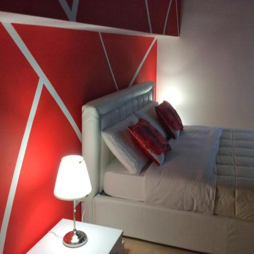 a bedroom with a bed with a red wall at Del Cavaliere in Castrovillari