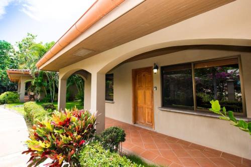 a house with a brown door and some flowers at Charming unit that sleeps 4 - with pool - walking distance from Brasilito Beach in Brasilito