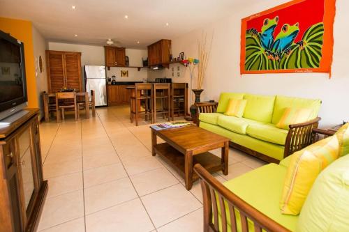 a living room with a green couch and a kitchen at Charming unit that sleeps 4 - with pool - walking distance from Brasilito Beach in Brasilito