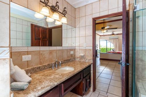 y baño con lavabo y espejo. en Big-beautiful unit in Flamingo sleeps 8-with breathtaking ocean views, en Playa Flamingo