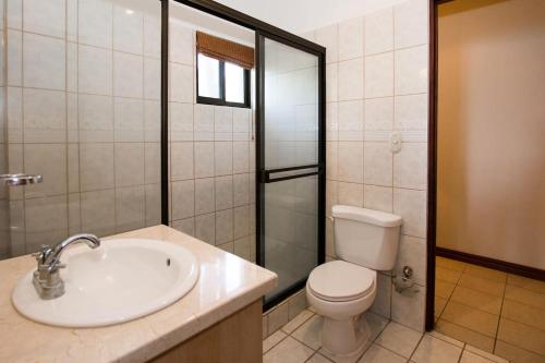 a bathroom with a sink and a toilet and a shower at Beautiful Condo in Peaceful Cliffside Location with a Private Balcony & Stunning Ocean and Mountain Views in Playa Flamingo
