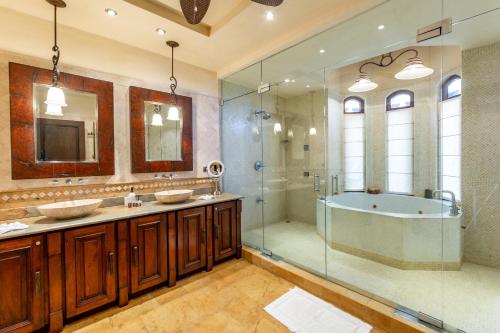 a bathroom with two sinks and a shower and a tub at Spectacular Mediterranean-Style Mansion with Beachfront Views in Playa Flamingo in Playa Flamingo