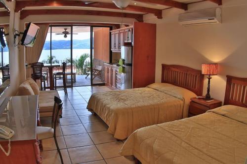 een hotelkamer met 2 bedden en een keuken met uitzicht bij Hotel room-style ocean-view unit in Flamingo with pool in Playa Flamingo