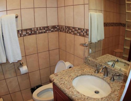 a bathroom with a sink and a toilet at Hotel room-style ocean-view unit in Flamingo with pool in Playa Flamingo