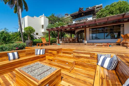 a wooden deck with benches on top of a house at Luxury Flamingo home with ocean view sleeps 10 - walking distance from beach in Playa Flamingo