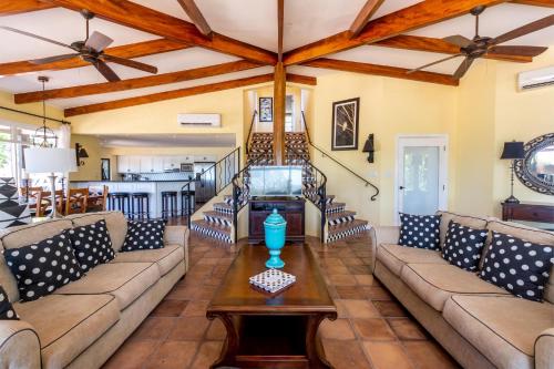 a living room with a couch and a table at Luxury Flamingo home with ocean view sleeps 10 - walking distance from beach in Playa Flamingo