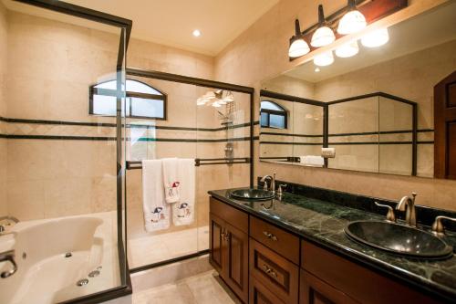 a bathroom with two sinks and a tub and a shower at Prestine ocean view 3BR condo in Playa Hermosa