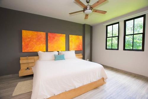 - une chambre avec un lit blanc et un ventilateur de plafond dans l'établissement Minimalist, Modern Design on 2nd Floor in Coco with Garden-View Balcony, à Coco