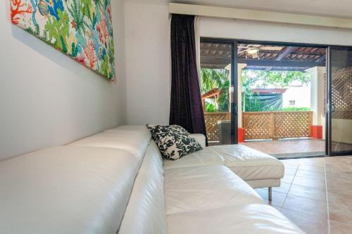Una sala de estar con un sofá blanco y una ventana. en Colorful & Private 2-Bedroom Condo Just a Short Walk from the Beach, en Coco