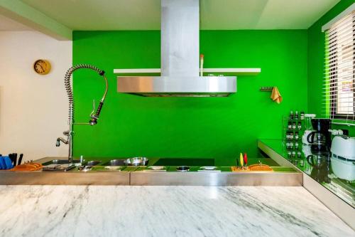 una cocina con una pared verde y un fregadero en Colorful & Private 2-Bedroom Condo Just a Short Walk from the Beach, en Coco