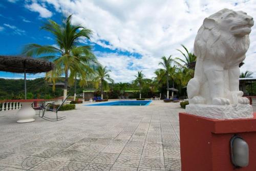 a statue of a lion next to a swimming pool at Tropical Condo with Spectacular Ocean Views, Panoramic Dining Terrace & Quick Walk to Beach in Coco