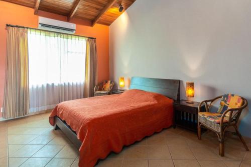 um quarto com uma cama, uma janela e uma cadeira em Coco Joya Condo - pool with 180 ocean view - all in walking distance em Coco