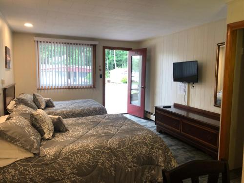 a bedroom with two beds and a flat screen tv at Marcotte Motor Court in Old Orchard Beach