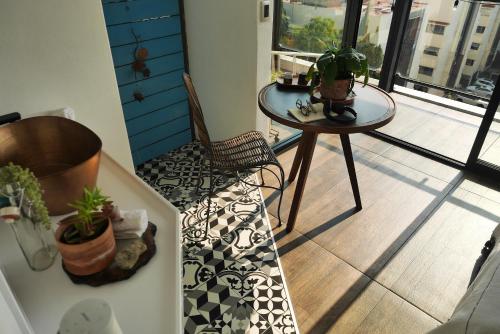 a balcony with a table and a chair on a floor at Loft REMEDIOS - penthouse CDMX - áreas comunes compartidas in Mexico City