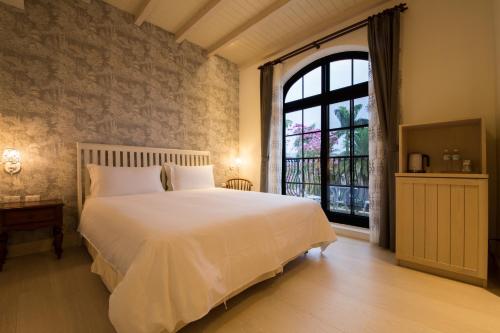 a bedroom with a large white bed and a window at Yun Shan Shuei Castle in Fengping