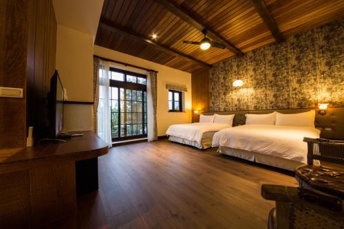 a hotel room with two beds and a television at Yun Shan Shuei Castle in Fengping