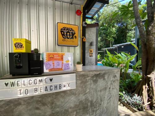 a welcome to beeper sign on a concrete counter at BeachBox@Koh Сhang in Ko Chang