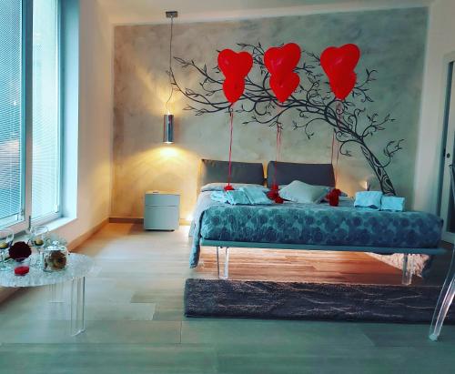 Un dormitorio con un árbol con corazones rojos. en Suite Amnesia, en Mesagne
