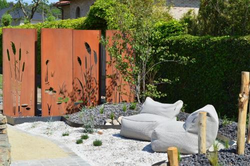 a garden with two white chairs and a fence at Relax B&B Lavendine Pure in Genk