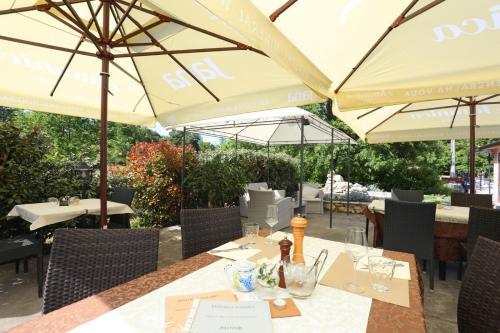a restaurant with tables and umbrellas on a patio at Hotel Tomažići in Santalezi