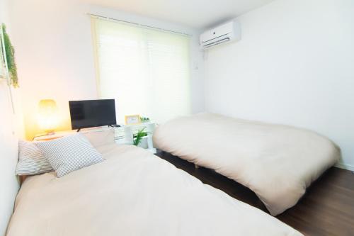 Posteľ alebo postele v izbe v ubytovaní Base Hanegi Apartment
