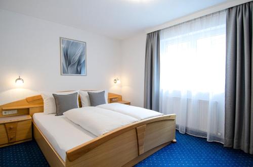 a bedroom with a large bed and a window at Xenia Apartments in Kappl