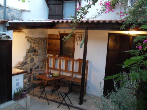 een kleine patio met een tafel en stoelen voor een huis bij Guesthouse Gonia in Pera Orinis