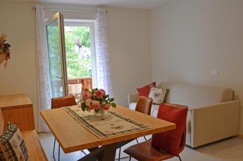 a dining room table with a vase of flowers on it at Casa vacanze Heidi e Peter Val di Rabbi in Rabbi