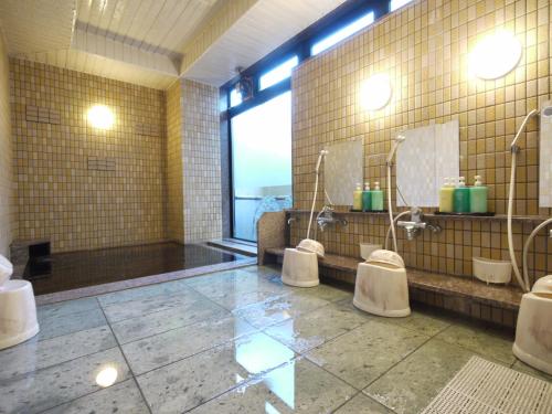 a bathroom with three toilets and a large window at Hotel Route-Inn Obihiro Ekimae in Obihiro