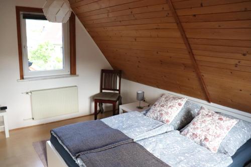 Schlafzimmer mit einem Bett mit Holzdecke in der Unterkunft Ferienhaus Geli in Wernigerode